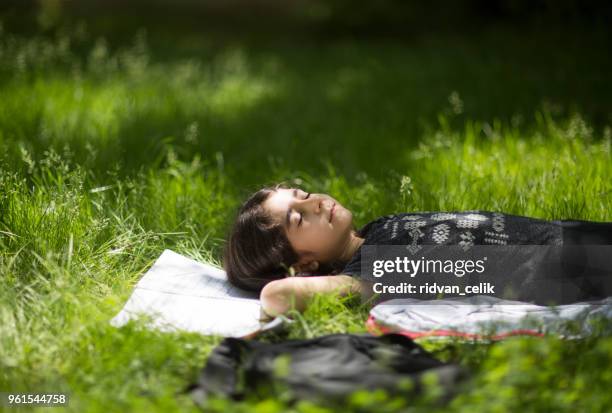 child relaxing in grass on field. - cowboy sleeping stock pictures, royalty-free photos & images