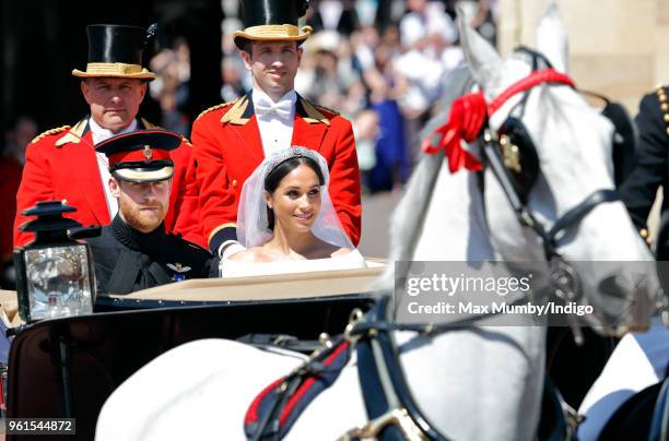 Prince Harry, Duke of Sussex and Meghan, Duchess of Sussex travel in an Ascot Landau carriage as they begin their procession through Windsor...