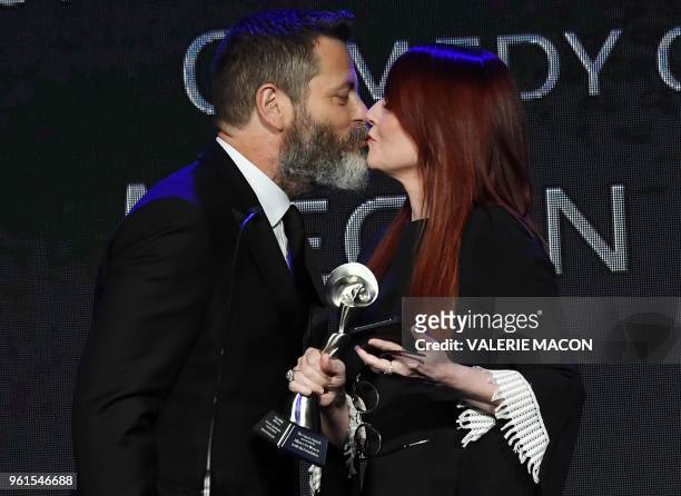 Nick Offerman kisses his wife actress Megan Mullally as he presents her with the award for best supporting actress in a comedy or musical, on stage...