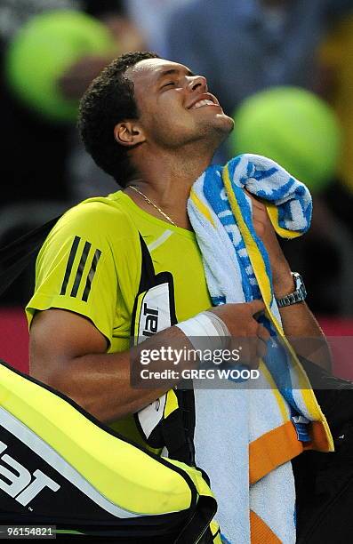 French tennis player Jo-Wilfried Tsonga smiles as he walks off the court after his fourth round mens singles match against Spanish opponent Nicolas...