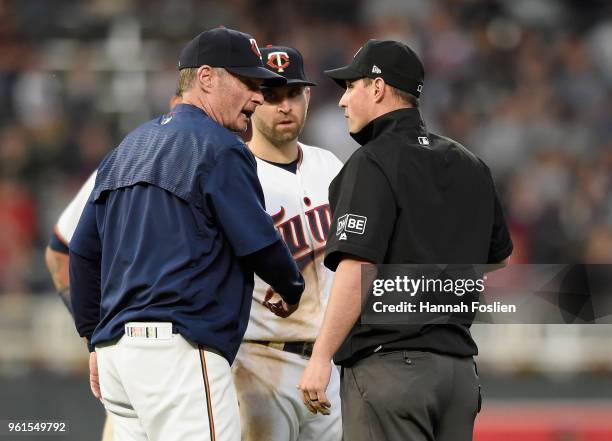 Manager Paul Molitor and Brian Dozier of the Minnesota Twins complain to second base umpire Quinn Wolcott that Dozier was interfered with fielding...