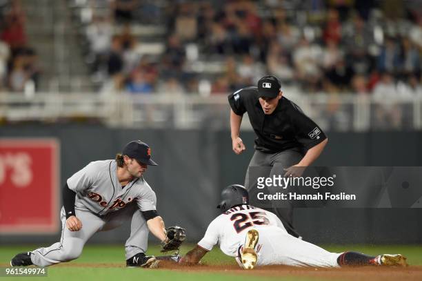 Byron Buxton of the Minnesota Twins slides safely ahead of the tag by Pete Kozma of the Detroit Tigers on an RBI single as umpire Quinn Wolcott waits...