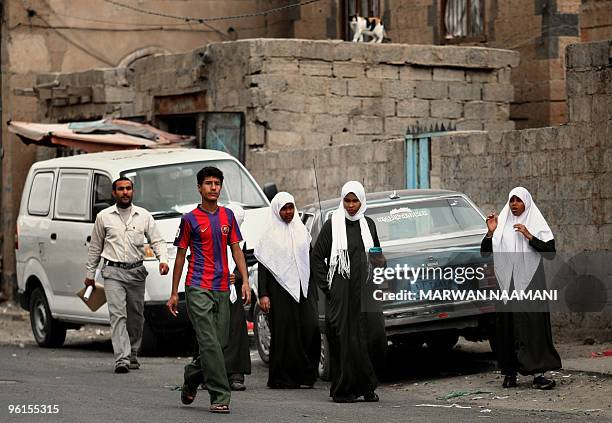 Yemeni youth sporting an FC Barcelnoa shirt walks past veiled schoolgirls in a street in Sanaa on January 25, 2010. The United States is set to hold...