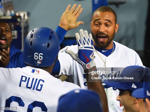 Yasiel Puig of the Los Angeles Dodgers is greeted in the dugout by Matt Kemp of the Los Angeles Dodgers after a solo home run in the sixth inning of...