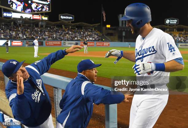 Chris Taylor of the Los Angeles Dodgers is greeted in the dugout by bench coach Bob Geren and manager Dave Roberts after hitting a two-run home in...