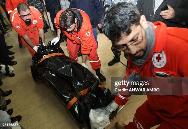 Lebanese Red Cross paramedics carry to the body of one of the victims of the Ethiopian Boeing 737 crash into the mortuary of a government hospital in...