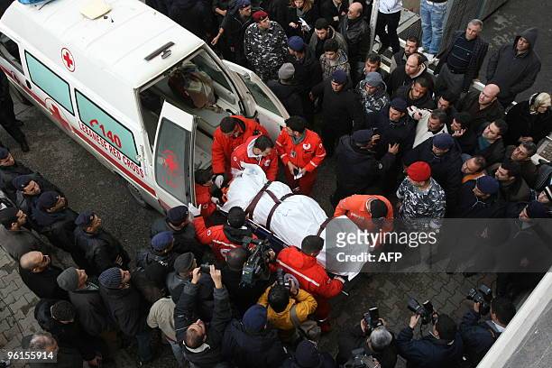Lebanese Red Cross paramedics carry to the body of one of the victims of the Ethiopian Boeing 737 crash into the mortuary of a government hospital in...
