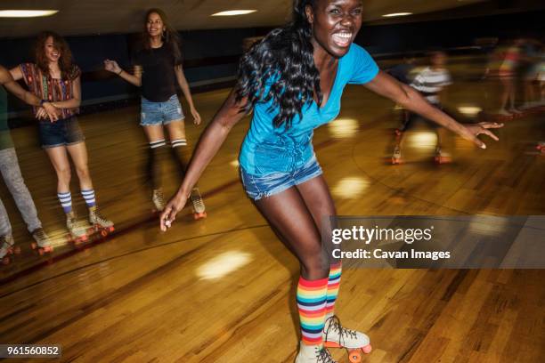 happy woman enjoying with friends at roller rink - roller skating - fotografias e filmes do acervo