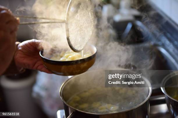 straining home-made gnocchi out of a pot with boiling water using a steel colander - boiling water stock pictures, royalty-free photos & images