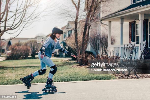 11 year old girl rollerblading in helmet, knee pads and elbow pads - inline skate 個照片及圖片檔