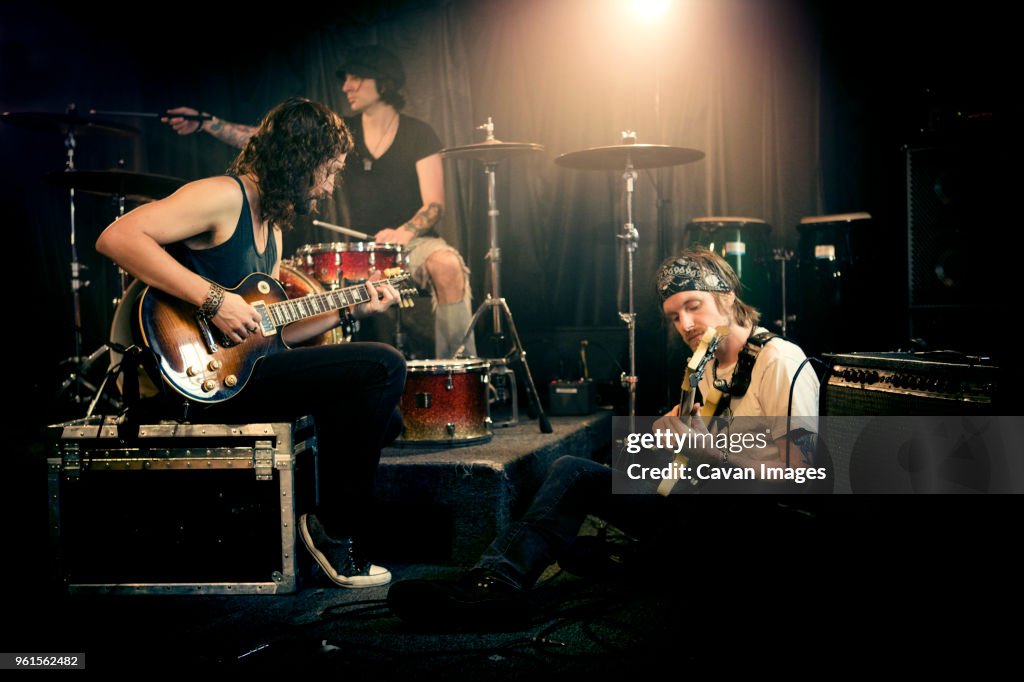 Musical band practicing in illuminated studio