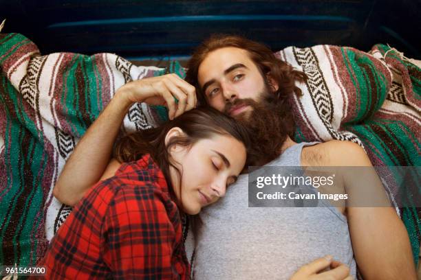 Overhead view of woman sleeping with thoughtful man in pick-up truck