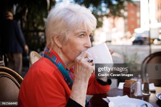 senior woman drinking coffee at sidewalk cafe - cup saucer stock pictures, royalty-free photos & images