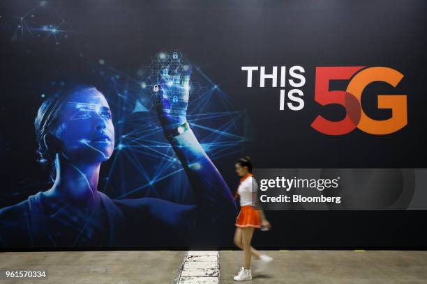 Woman walks past an advertisement for SK Telecom Co. At the World IT Show 2018 in Seoul, South Korea, on Wednesday, May 23, 2018. The show runs...