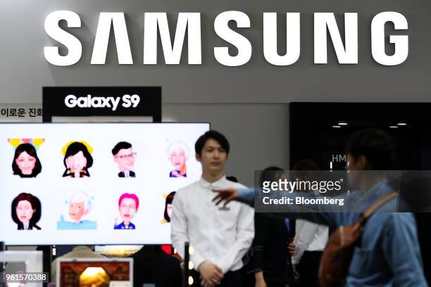 Visitors walk past the Samsung Electronics Co. Booth at the World IT Show 2018 in Seoul, South Korea, on Wednesday, May 23, 2018. The show runs...