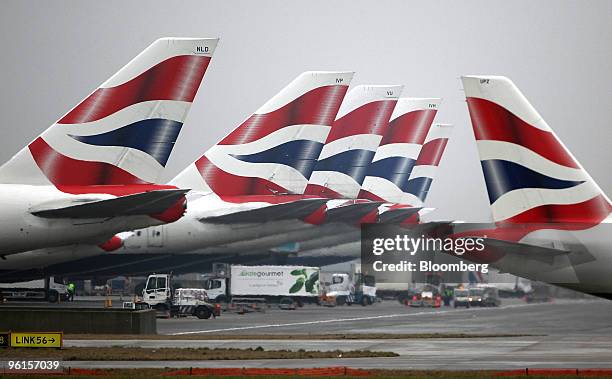 British Airways airplane taxis towards the runway, passing jets sitting at Terminal 5 at Heathrow airport in London, U.K., on Monday, Jan. 25, 2010....