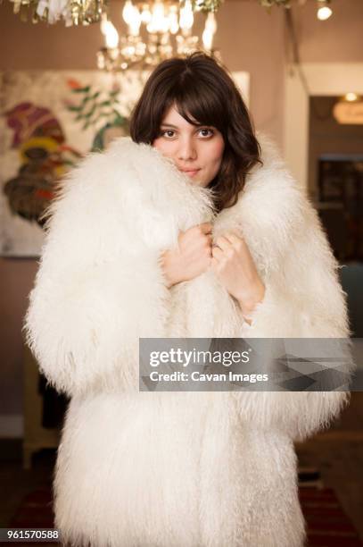 portrait of confident owner wearing fur coat at boutique - fur coat stock pictures, royalty-free photos & images