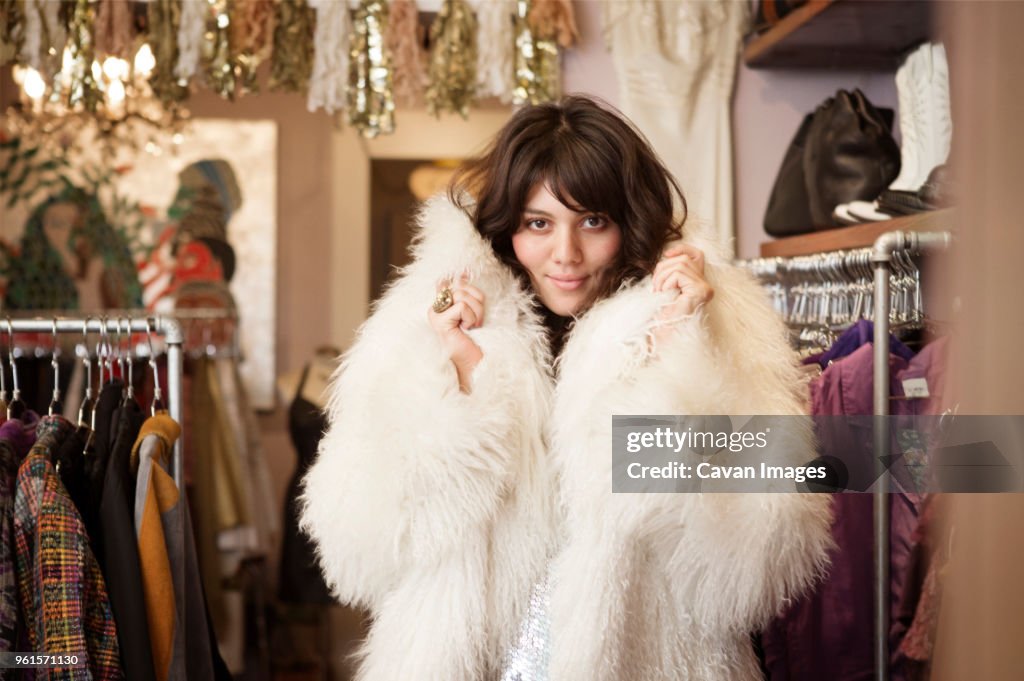 Portrait of young woman wearing fur coat at boutique