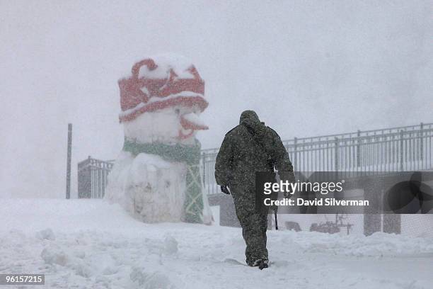 An Israeli soldier walks through a snowstorm towards a military base on the snow-covered slopes of the strategic plateau that Israel captured from...
