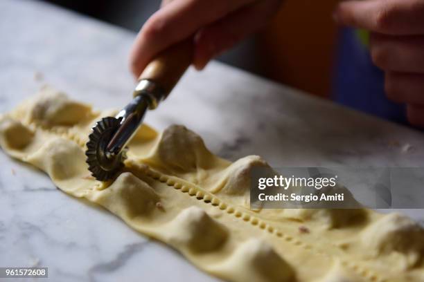 separating pasta parcels using a pasta cutter wheel to make tortellini - tortellini bildbanksfoton och bilder