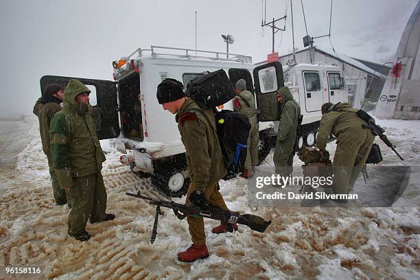 Israeli soldiers board a snow-mobile at a military base as they head to their outpost higher up the snow-covered slopes January 25, 2010 of Mount...