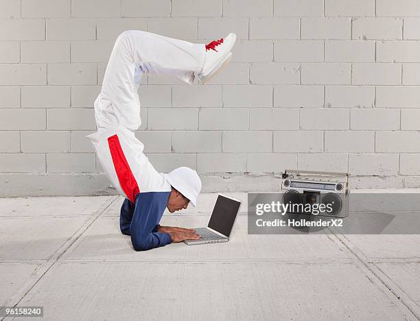 man on laptop while in yoga/breakdancing pose - multitasking stock-fotos und bilder