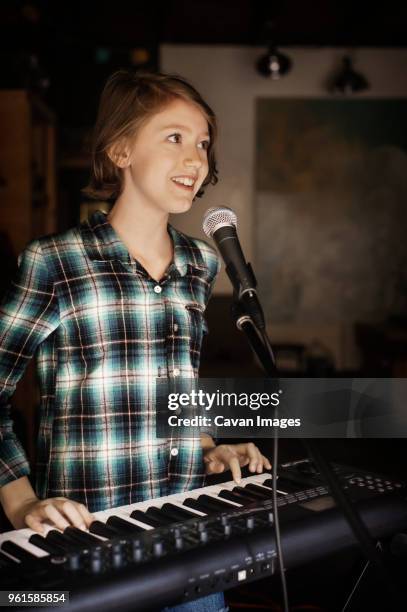 happy girl singing and playing piano - pianist front fotografías e imágenes de stock