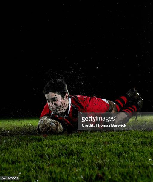 male rugby player diving with ball scoring try - chaussures à crampons photos et images de collection