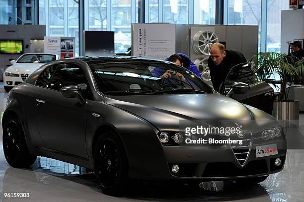 Visitors look at an Alfa Romeo Brera automobile inside the Mirafiori Motor Village in Turin, Italy on Friday, Jan. 22, 2010. Fiat SpA, the Italian...
