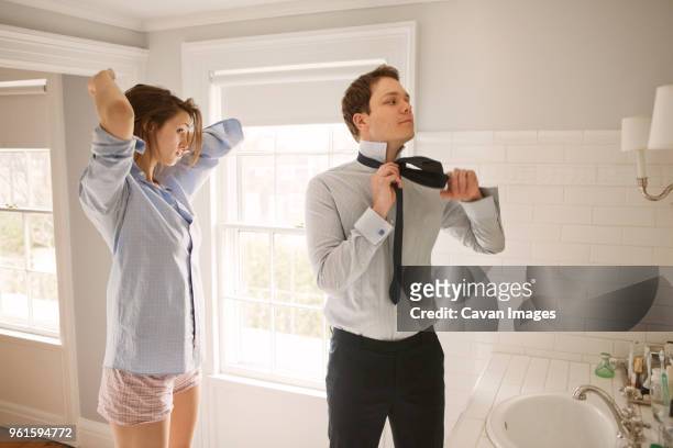 couple getting dressed while standing by bathroom sink - bathroom sink stock-fotos und bilder