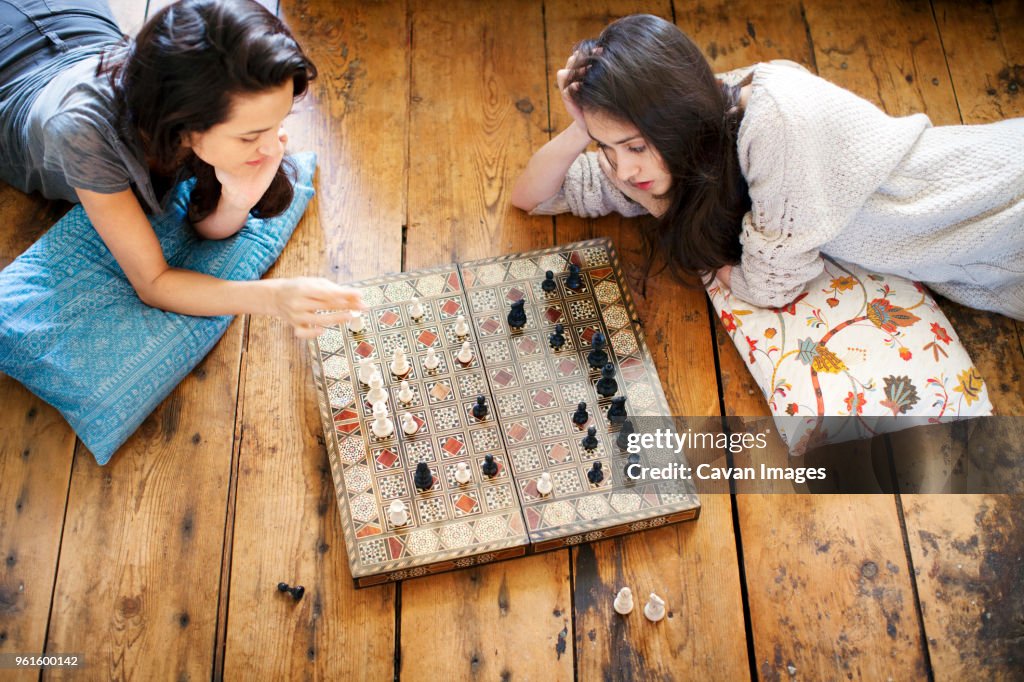 High angle view of sisters playing chess at home