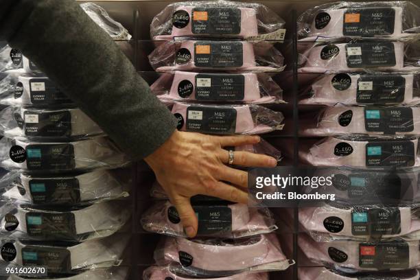 An employee adjusts packets of mens shirts on display inside a branch of Marks & Spencer Group Plc in London, U.K., on Tuesday, Dec. 5, 2017. A...