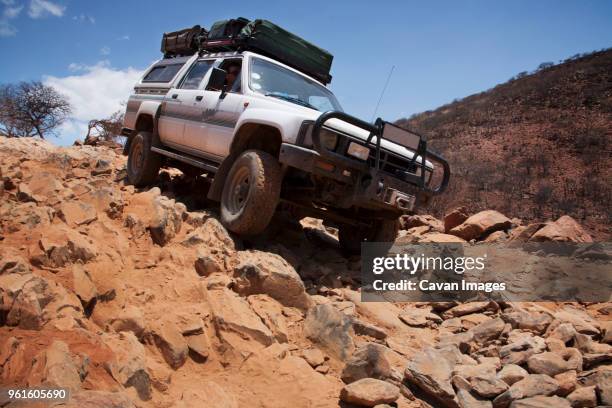 man riding off-road vehicle on rocks - vehículo de todo terreno fotografías e imágenes de stock