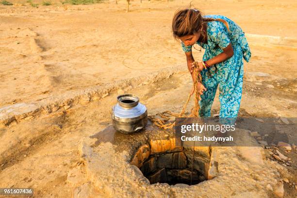 indiase meisje tekening water uit een put, rajasthan - rajasthani youth stockfoto's en -beelden