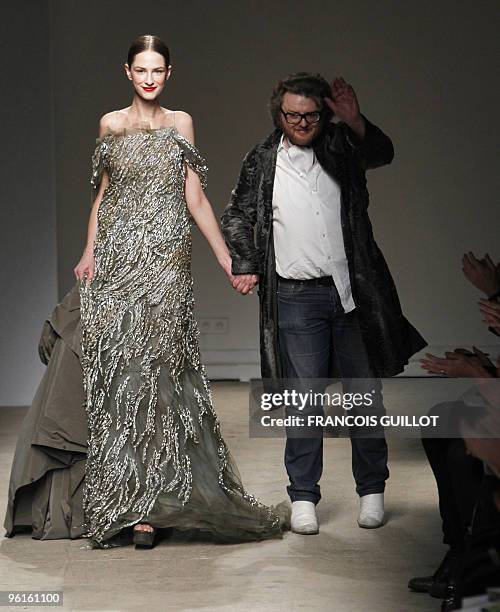 Dutch designer Josephus Thimister gestures near a model presenting one of his creation during the spring-summer 2010 haute couture collection show on...