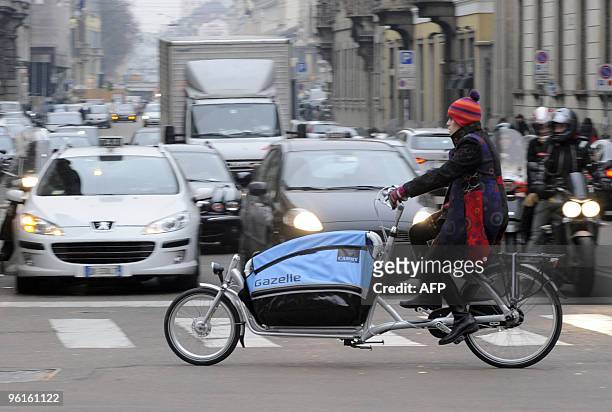 Awoman rides her bicycle downtown Milan on January 25, 2010. Milan's local councillors Pierfrancesco Majorino and Maurizio Baruffi said the day...