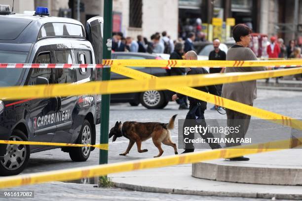 Police secures the area with a sniffer dog on the site of a bomb alert, on May 23, 2018 at the "Credito Artigiano" bank Via della Conciliazione near...