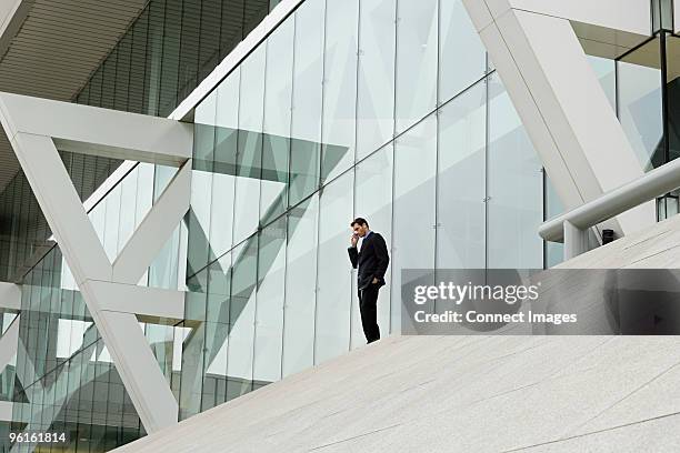 looking up to a businessman speaking on a mobile - baltimore convention center stock pictures, royalty-free photos & images