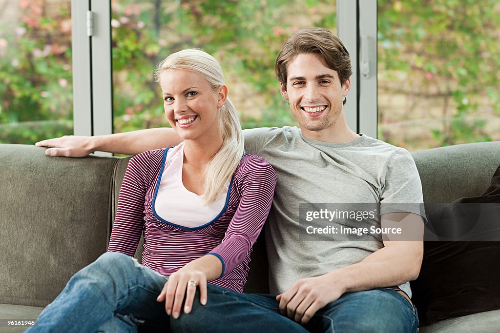 Young couple sitting on sofa at home