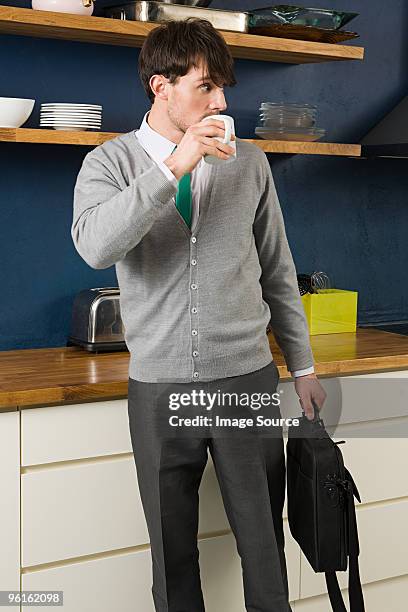 young man drinking coffee in kitchen - laptop bag stock pictures, royalty-free photos & images