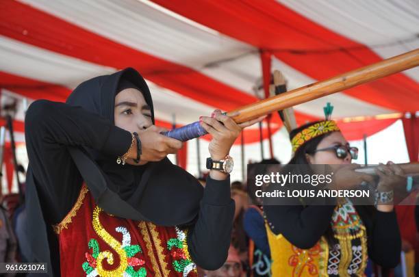 This picture taken in Pontianak on May 22, 2018 shows a female Muslim of Dayak tribes participating in the Sumpit competition during the Gawai Dayak...