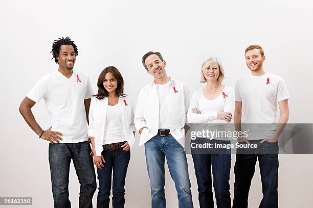 people wearing aids awareness ribbons - red shirt stock pictures, royalty-free photos & images