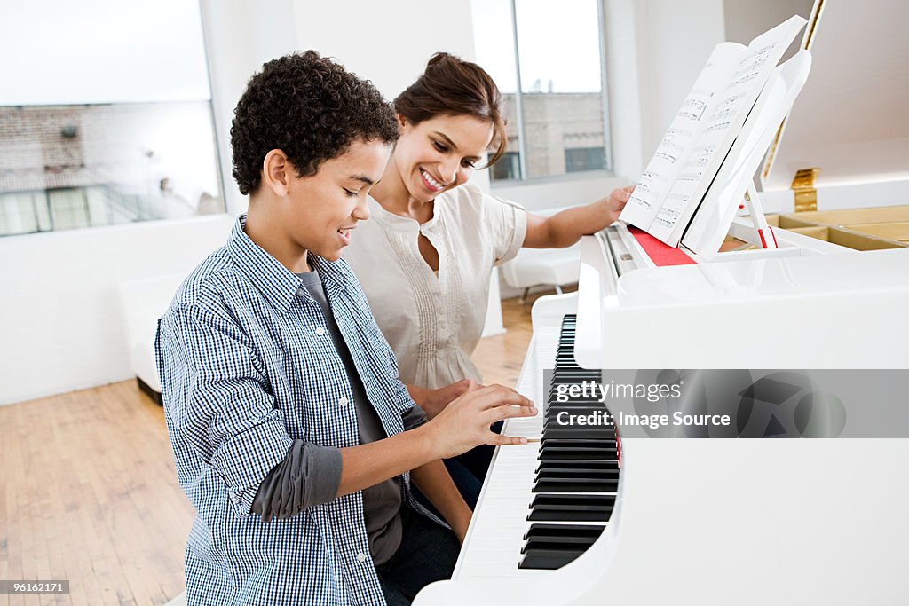 Femme donner leçon de piano pour garçon