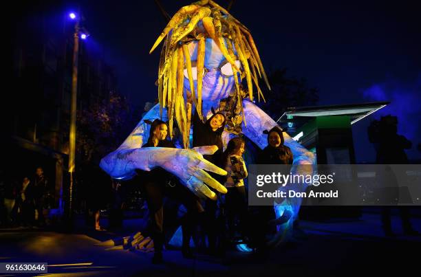People get up close and personal with the puppet creature named Marri Dyin during a media preview for Vivid Sydney on May 23, 2018 in Sydney,...