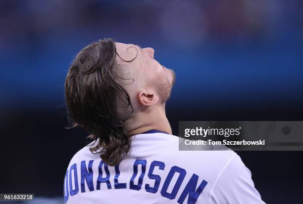 Josh Donaldson of the Toronto Blue Jays looks up as he waits on first base during an injury delay in the third inning during MLB game action against...