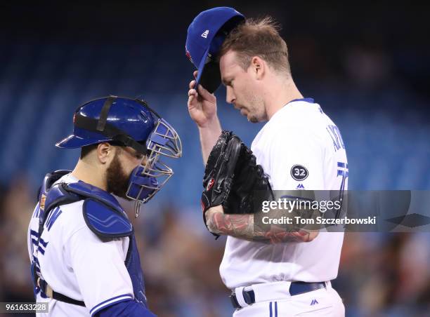 John Axford of the Toronto Blue Jays is visited on the mound by Russell Martin shortly after giving up a two-run home run in the sixth inning during...