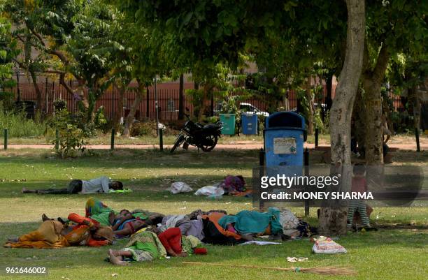 Daily labourers take an afternoon nap under the shade of a tree on a hot summer day in New Delhi on May 23, 2018. Temperatures in the Indian national...