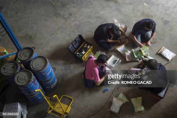 This picture taken on March 13, 2018 shows police and Ministry of Agriculture personnel conducting a raid against fake pesticide in a warehouse in...