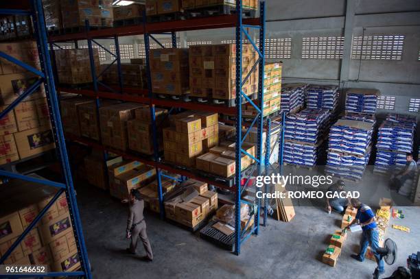 This picture taken on March 13, 2018 shows police and Ministry of Agriculture personnel inspecting alleged fake pesticides seized during a raid in a...