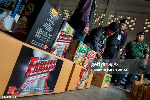 This picture taken on March 13, 2018 shows police and Ministry of Agriculture personnel raiding a warehouse looking for pesticides products in Suphan...